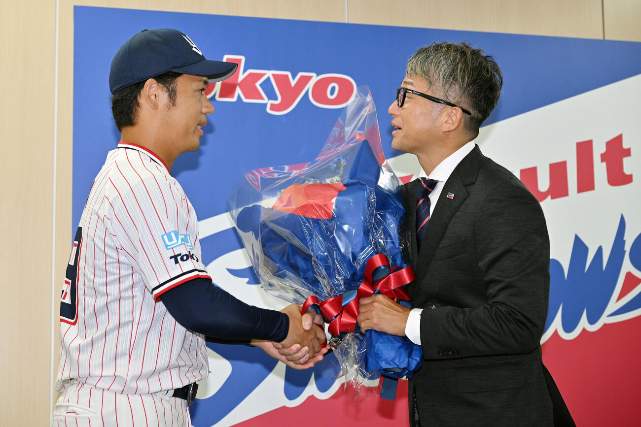 引退会見でヤクルト石川雅規（右）は小川泰弘から花束を受け取る（撮影・滝沢徹郎）