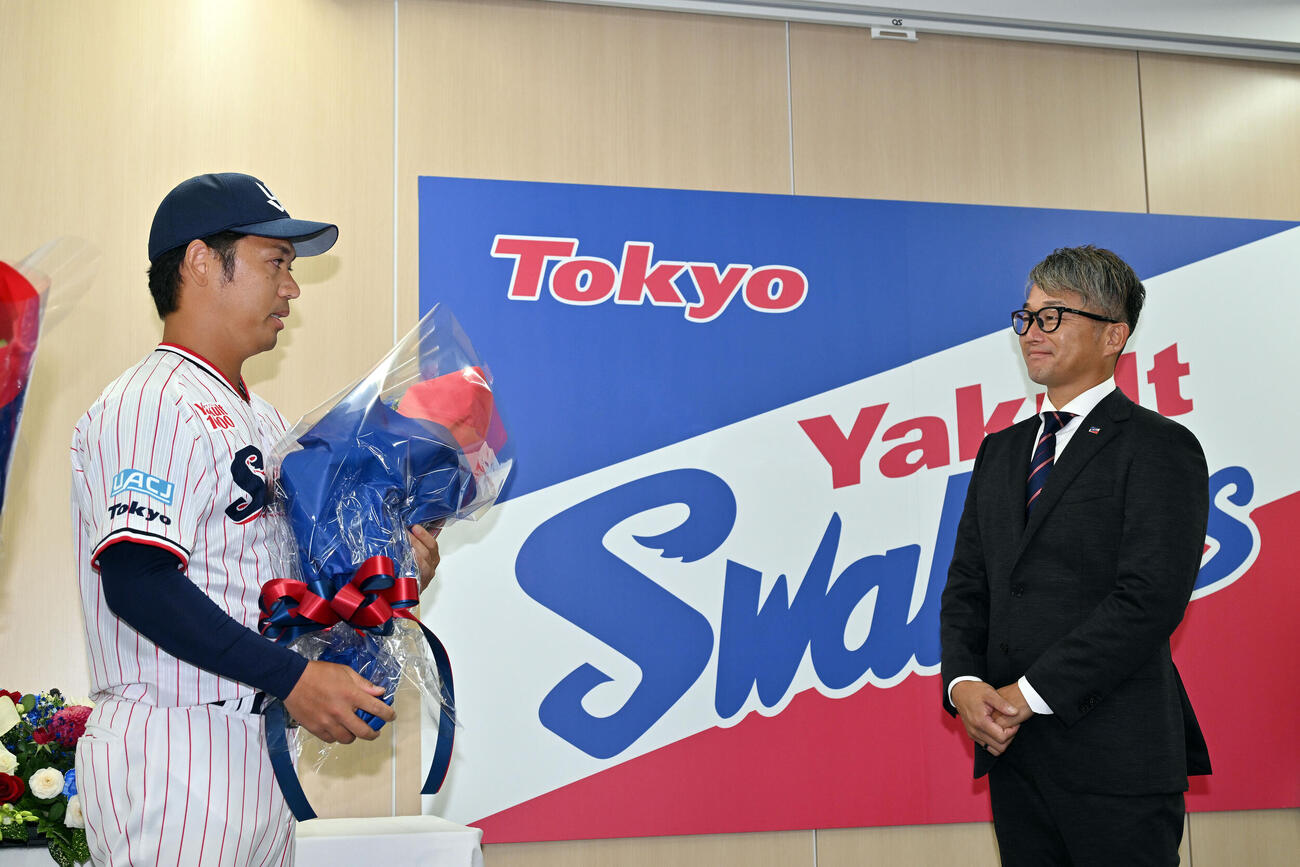 引退会見でヤクルト石川雅規（右）は小川泰弘から花束を受け取る（撮影・滝沢徹郎）