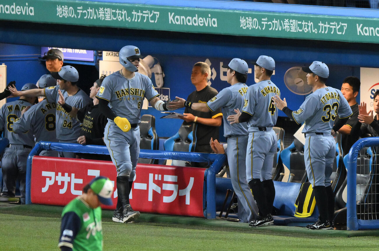 ヤクルト対阪神　1回表阪神1死一、三塁、前川右京の犠飛で生還した佐藤輝明（手前）はチームメートとタッチをかわす（撮影・滝沢徹郎）