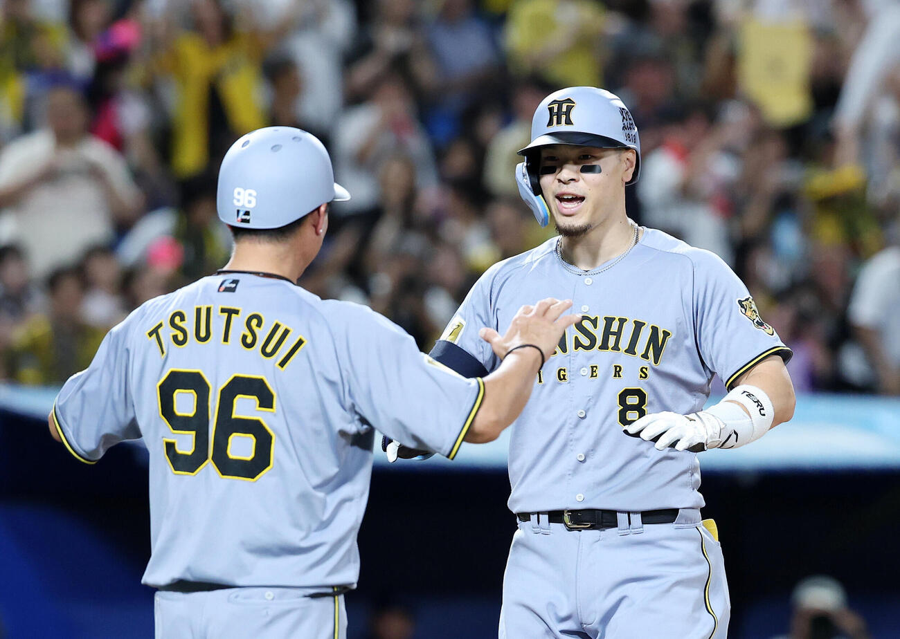 ヤクルト対阪神　5回表阪神1死一塁、佐藤輝明（右）は2点本塁打を放ち筒井壮コーチと喜ぶ（撮影・鈴木正人）