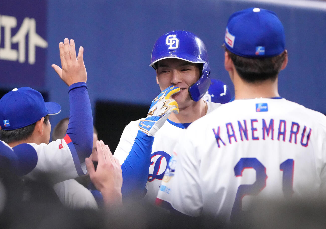 中日対広島　3回裏中日2死一塁、石川昂弥（右から2人目）は2点本塁打を放ちナインとタッチを交わす（撮影・森本幸一）