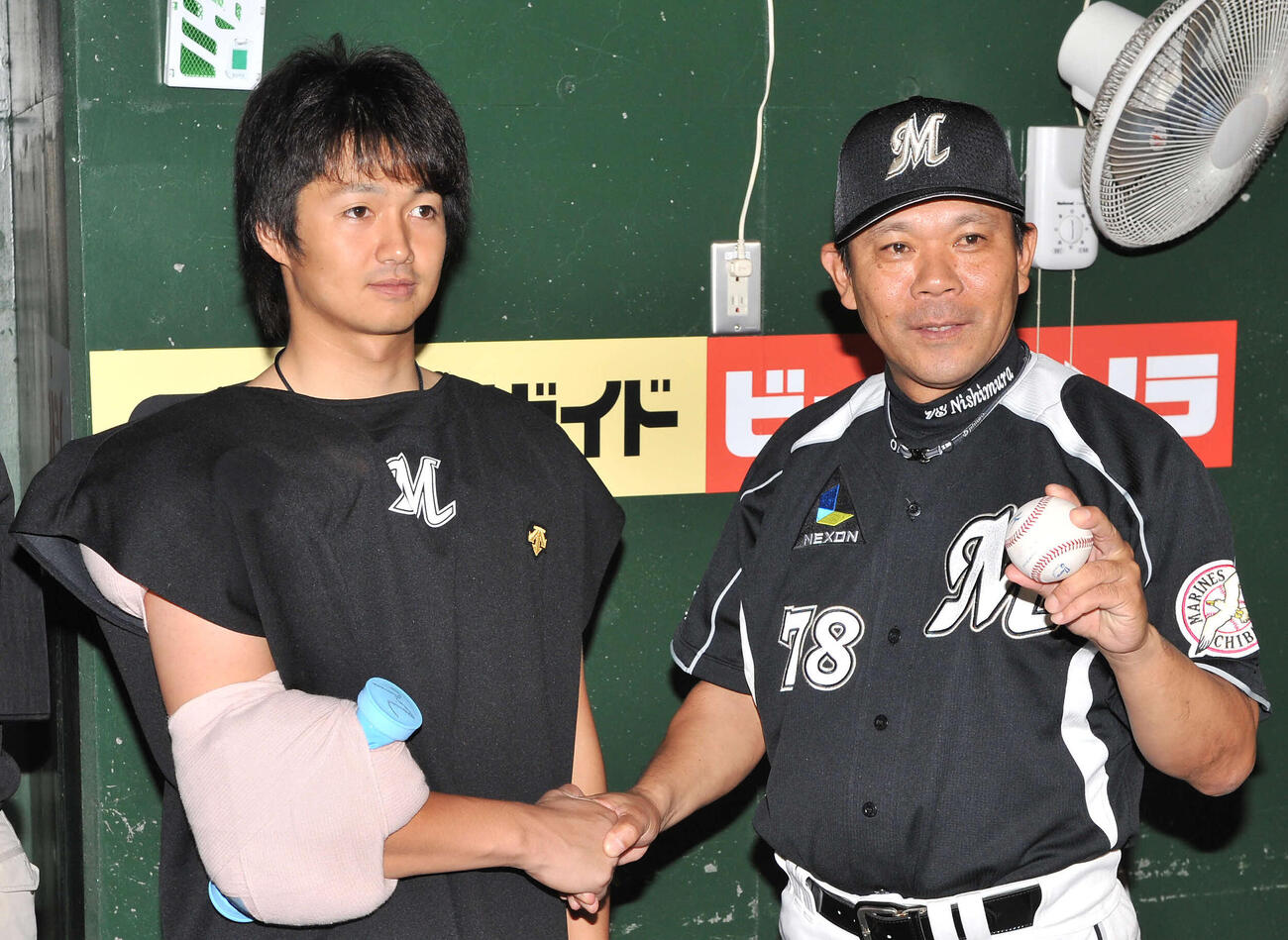 西武対ロッテ　西村徳文監督（右）は4000勝の記念球を手に、唐川侑己と握手する＝2011年9月7日