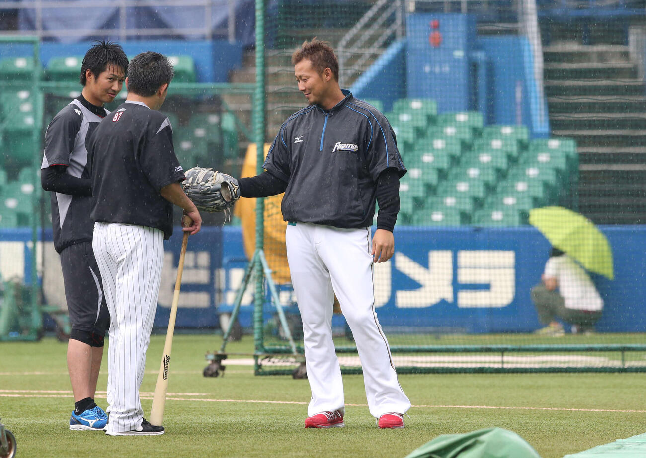2015年7月、ロッテ対日本ハム　雨が降るグラウンドで話す日本ハム中田（右）とロッテ唐川（左）