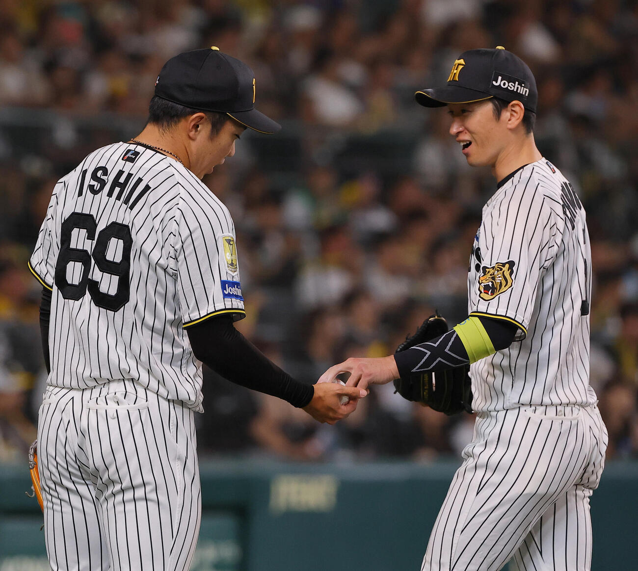阪神対DeNA　復帰登板を無失点で抑えた阪神石井大智（左）は近本光司から記念球を受け取る（撮影・上田博志）