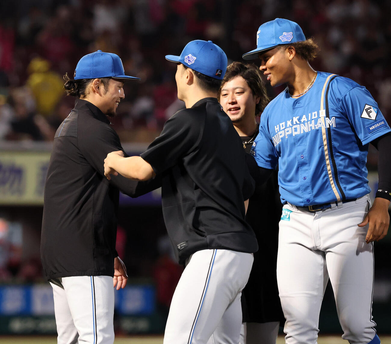 楽天対日本ハム　9勝目を挙げた日本ハム伊藤大海（左）は郡司裕也（手前）らから祝福され、笑みを浮かべる（撮影・浅見桂子）