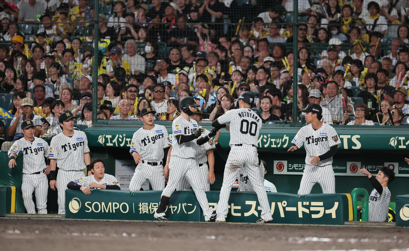 阪神対DeNA 5回裏阪神1死二、三塁、中野拓夢（手前左は二塁ゴロの間に1点を奪い、生還した元山飛優に迎えられる（撮影・宮崎幸一）