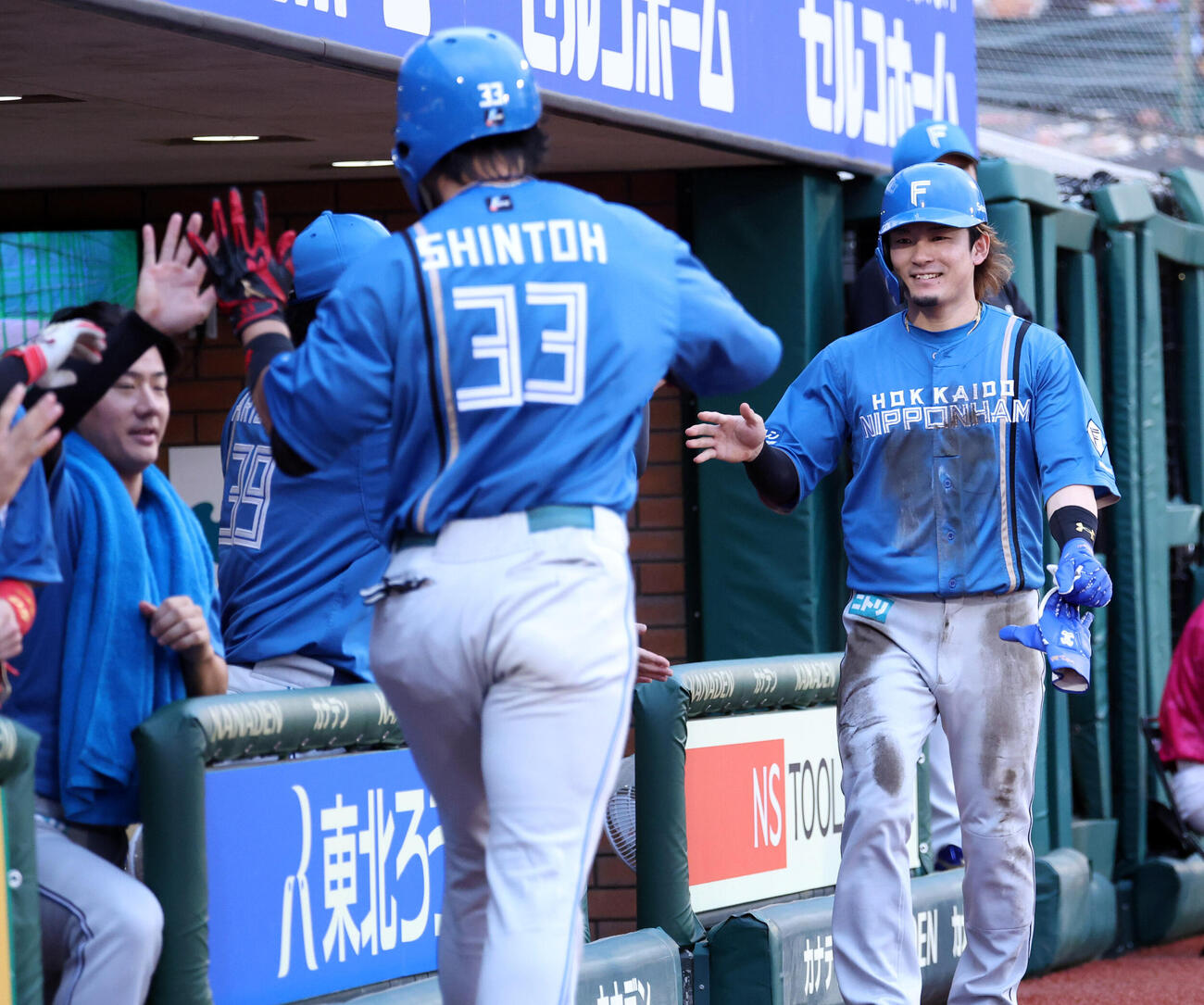 楽天対日本ハム　4回表日本ハム1死一、三塁、進藤勇也（手前）のスクイズで生還した水野達稀はナインとハイタッチ（撮影・浅見桂子）