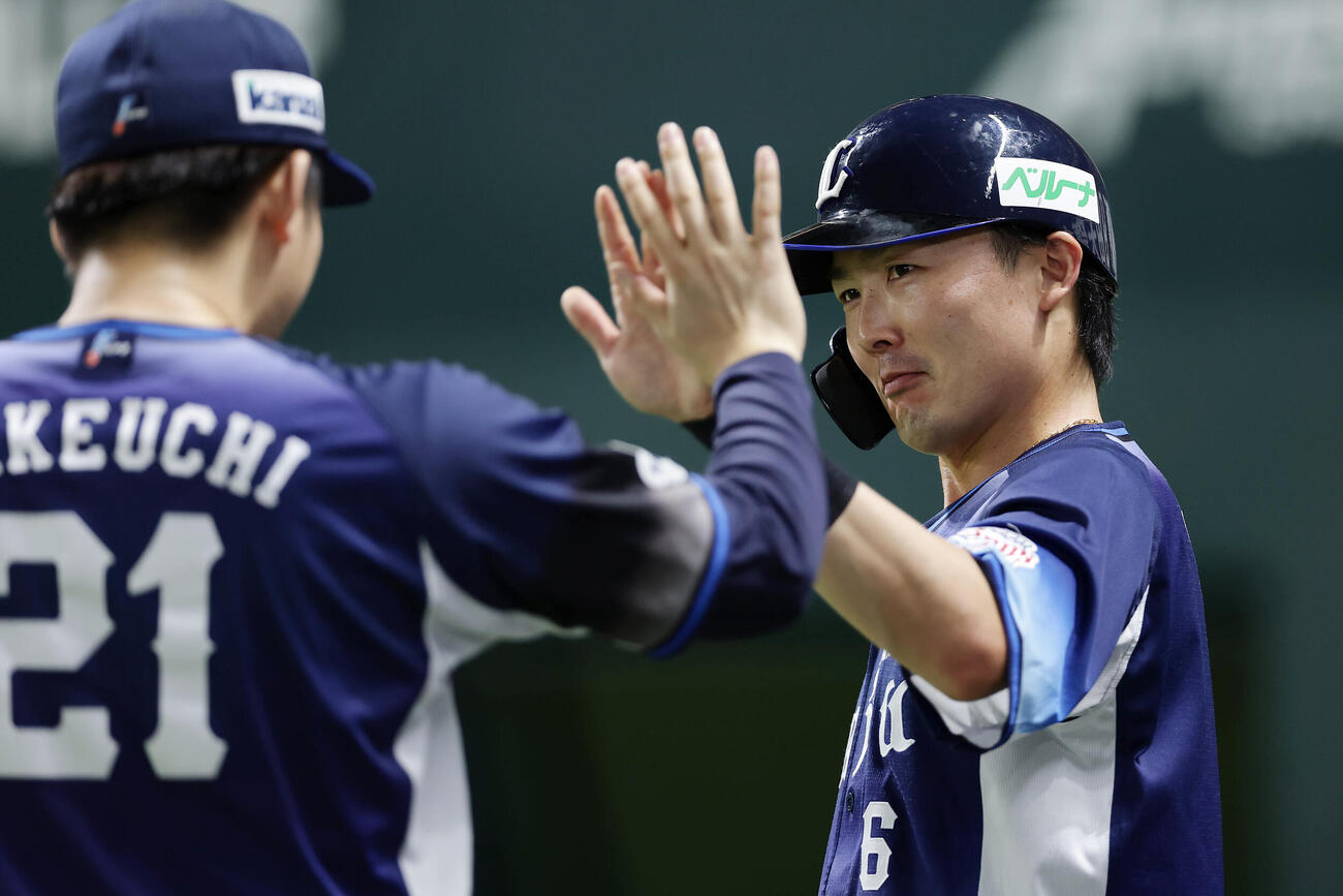 ソフトバンク対西武　2回表西武2死二、三塁、小島大河の3点本塁打で生還し、武内夏暉（左）とタッチを交わす源田壮亮（撮影・前田充）