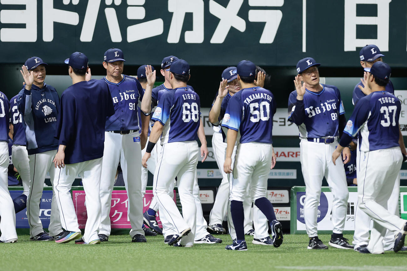 ソフトバンク対西武　ソフトバンクに勝利し、ナインらとタッチを交わす西武西口文也監督（左端）（撮影・前田充）