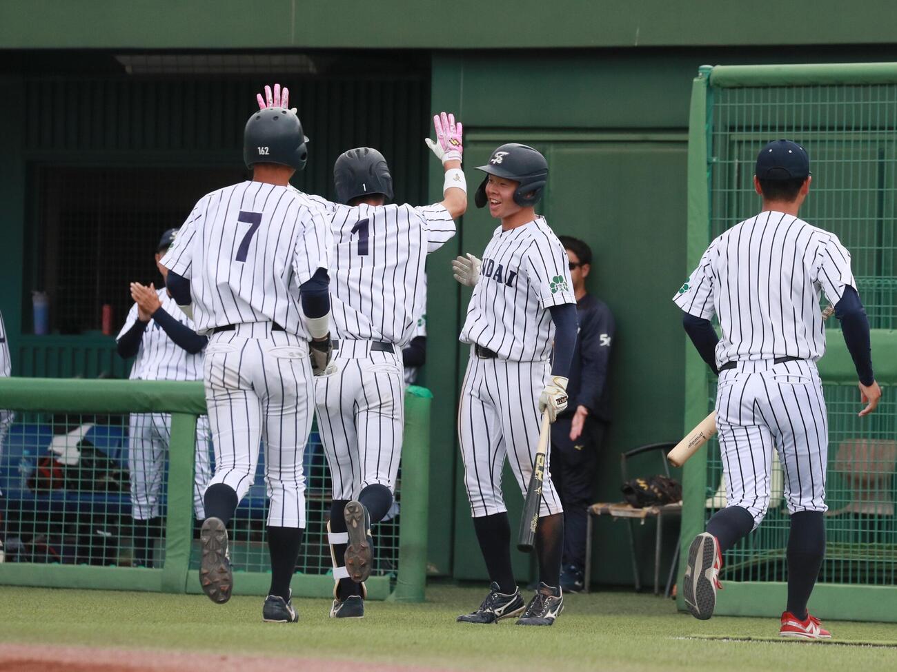 仙台大対東北大　6回3ランを放ちベンチに迎えられる仙台大・新保玖和内野手（右から3番目）（撮影・高橋香奈）