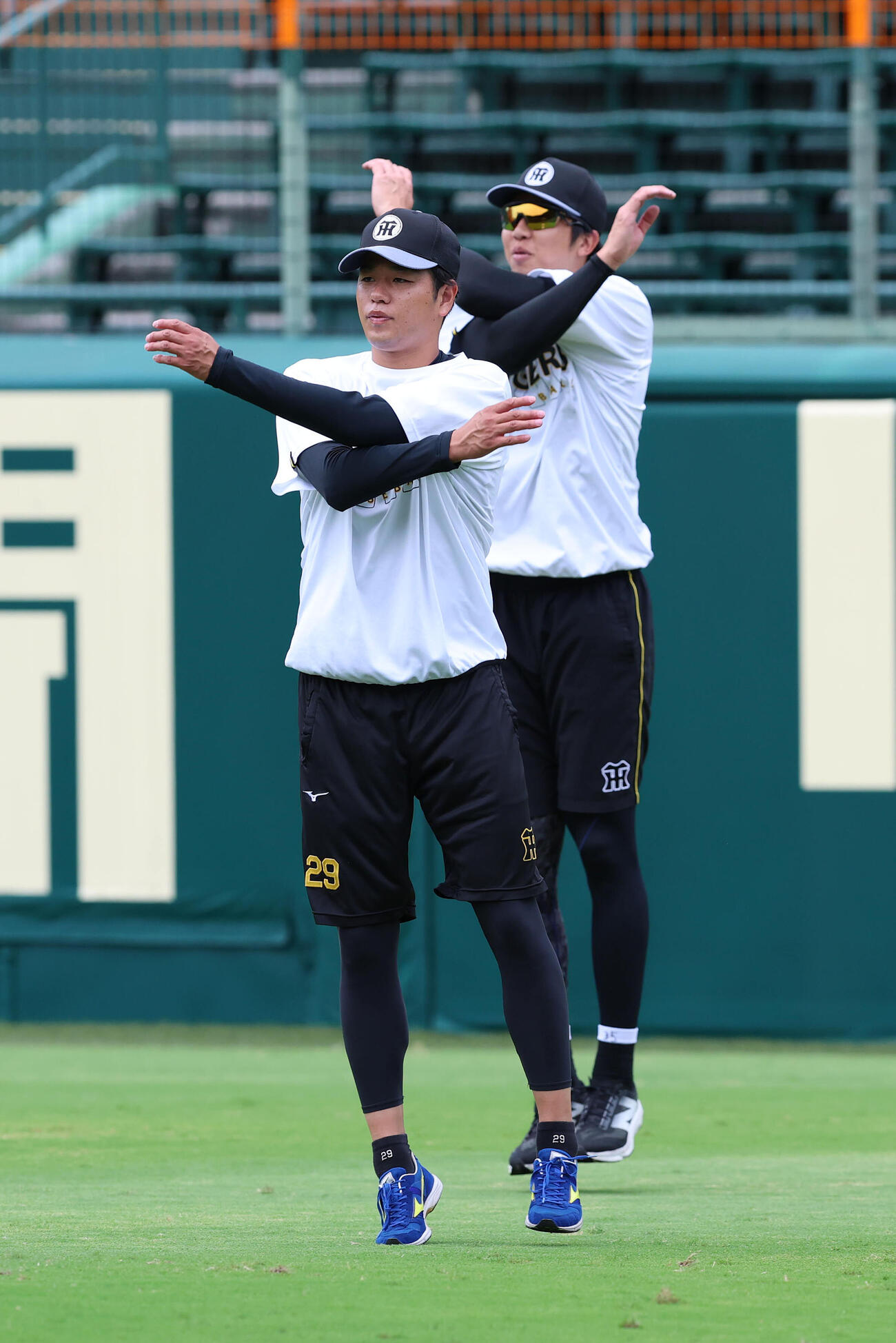 投手指名練習で並んでウオーミングアップする高橋遥人（手前）と才木浩人（撮影・白石智彦）