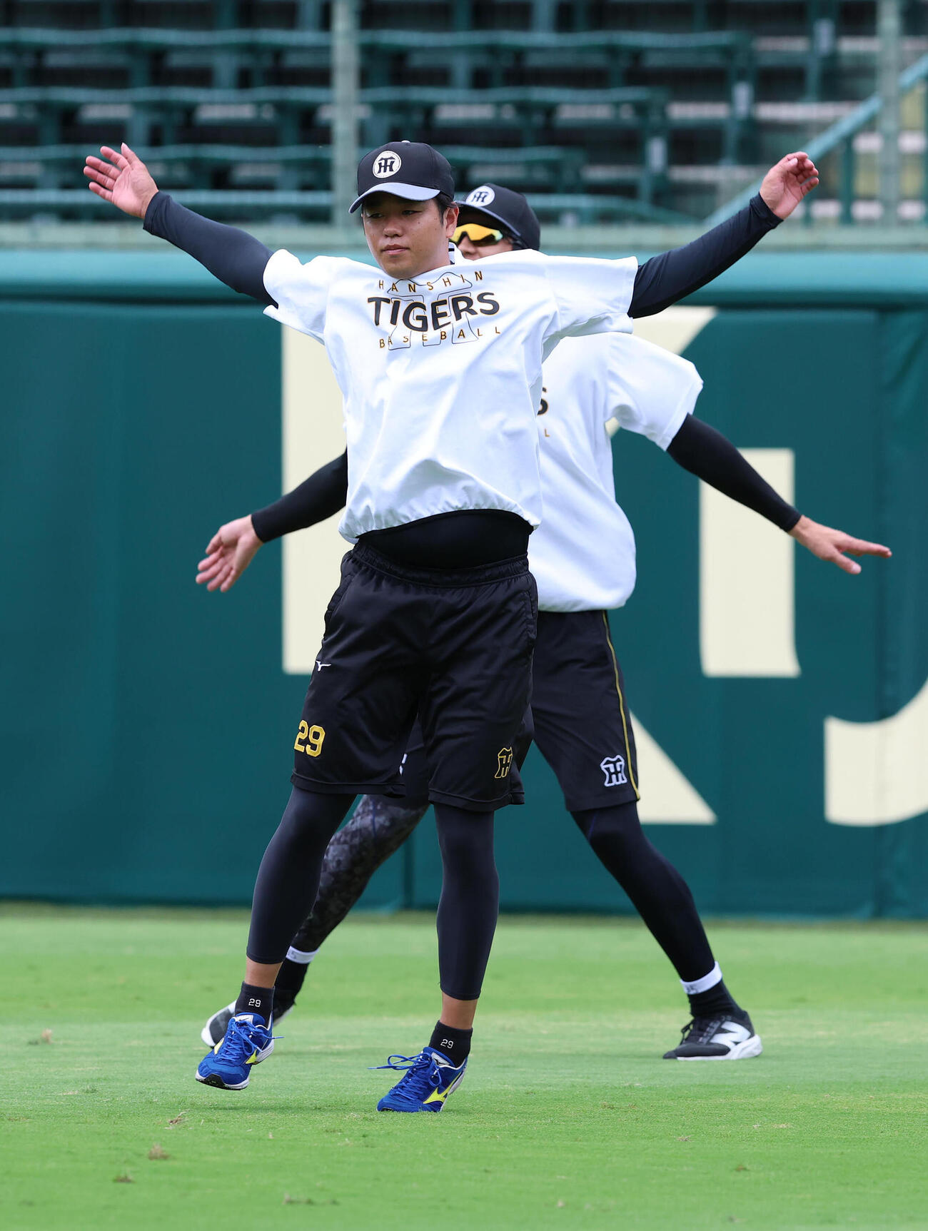 投手指名練習で並んでウオーミングアップする高橋遥人（手前）と才木浩人（撮影・白石智彦）