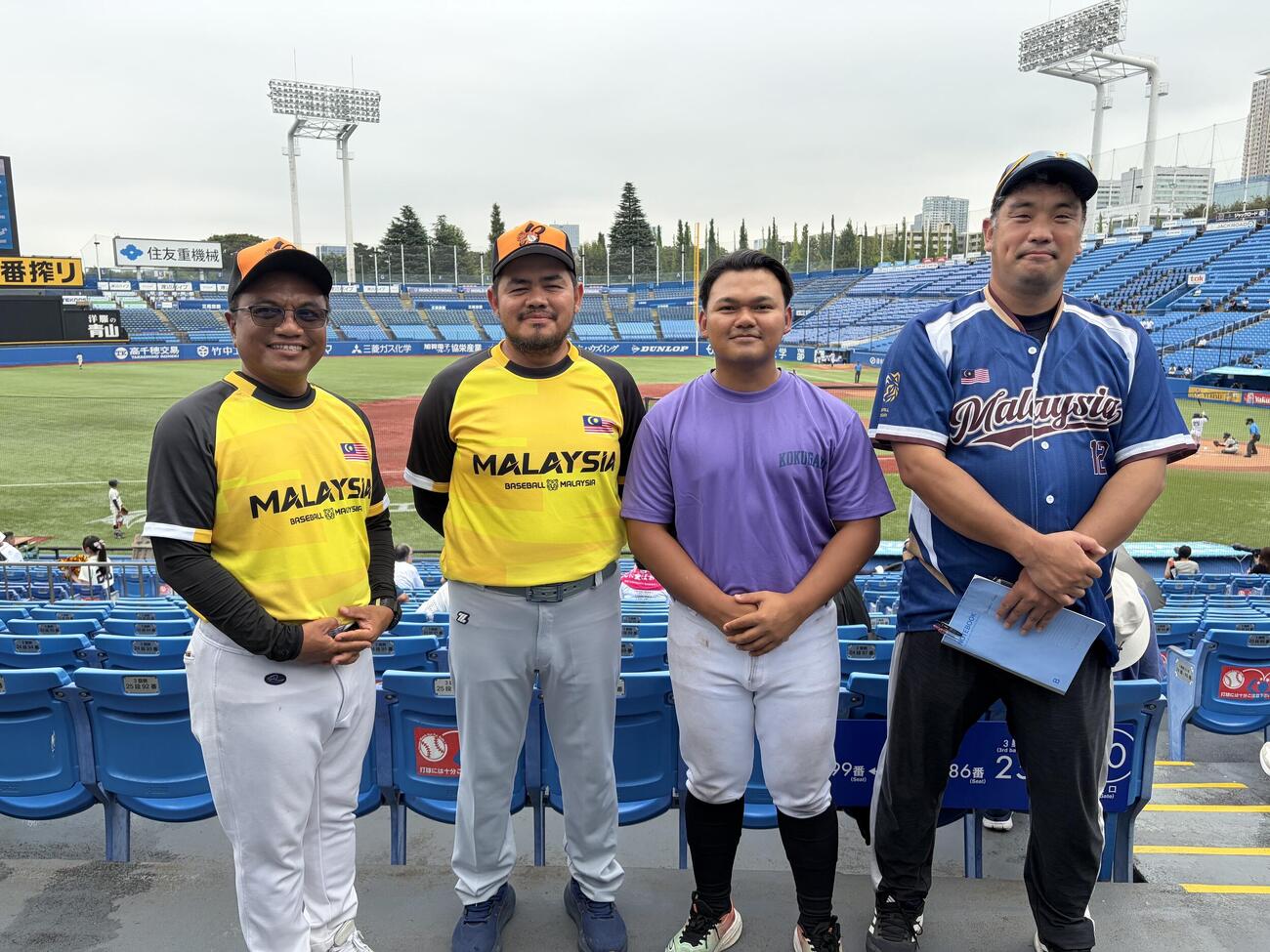 国学院大ー立正大を観戦するマレーシアのナショナルチームの（左から）アクマルコーチ、ウカハリコーチ、ハキム投手、大熊信夫コーチ（撮影・保坂淑子）