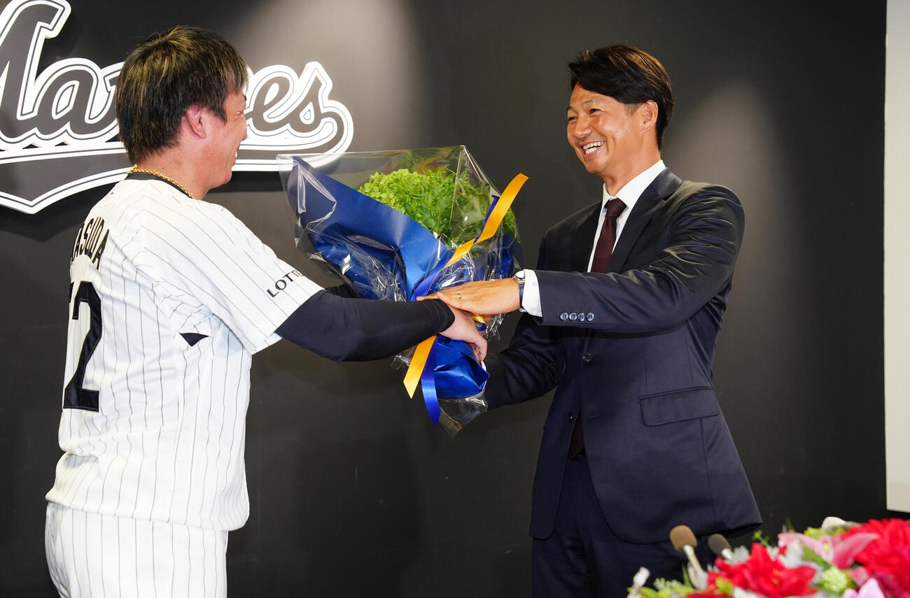 引退会見で益田直也（左）から花束を受け取るロッテ唐川侑己（撮影・鈴木みどり）