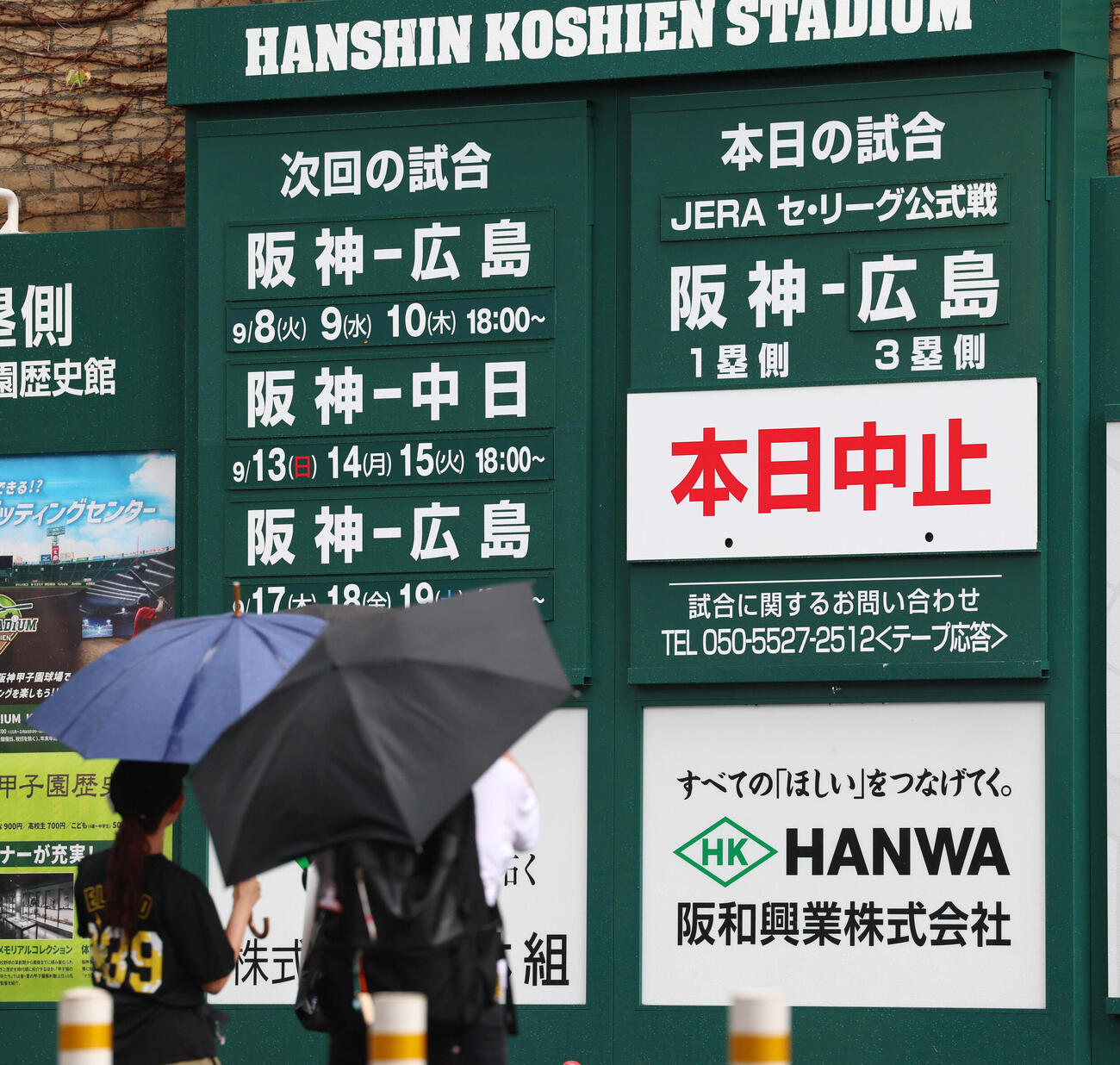 阪神対広島　中止看板のかかる掲示板を見上げるファン（撮影・加藤哉）