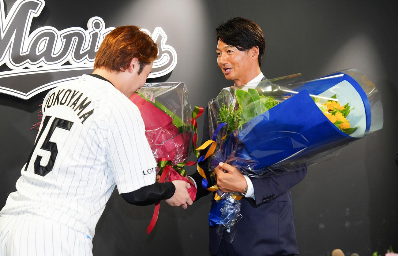 引退会見で横山陸人（左）から花束を受け取るロッテ唐川侑己（撮影・鈴木みどり）