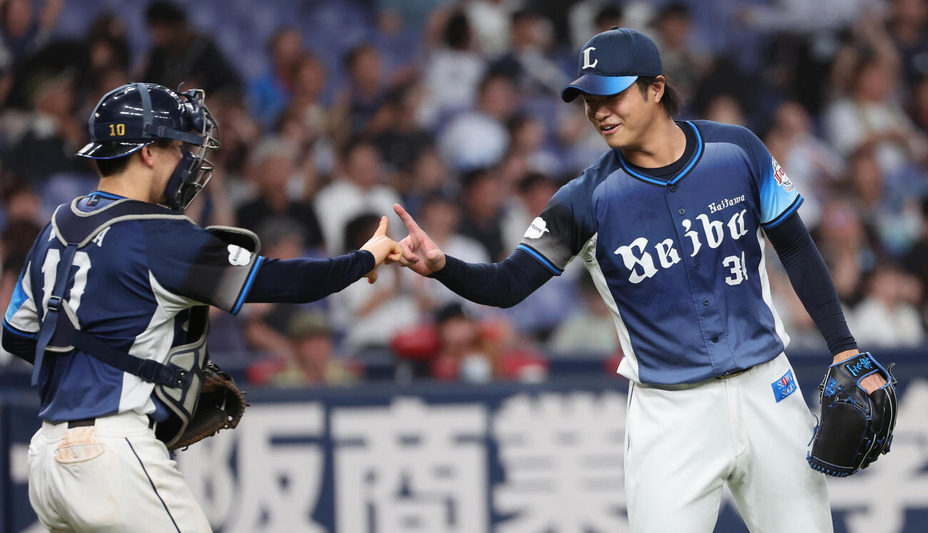 オリックス対西武　最後を締めた西武2番手甲斐野央（右）は小島大河捕手と指タッチ（撮影・西尾就之）