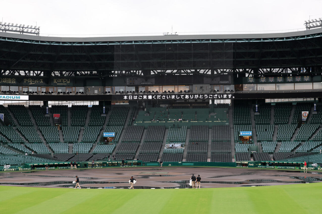 阪神対広島　雨で濡れた甲子園球場内野グラウンドの整備を始める阪神園芸職員（撮影・加藤哉）