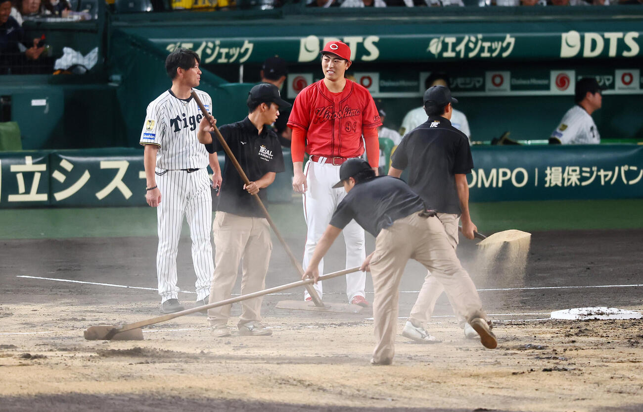 阪神対広島　1回表を終え一塁付近に新しい砂を入れる阪神園芸のグラウンドキーパー（撮影・加藤哉）