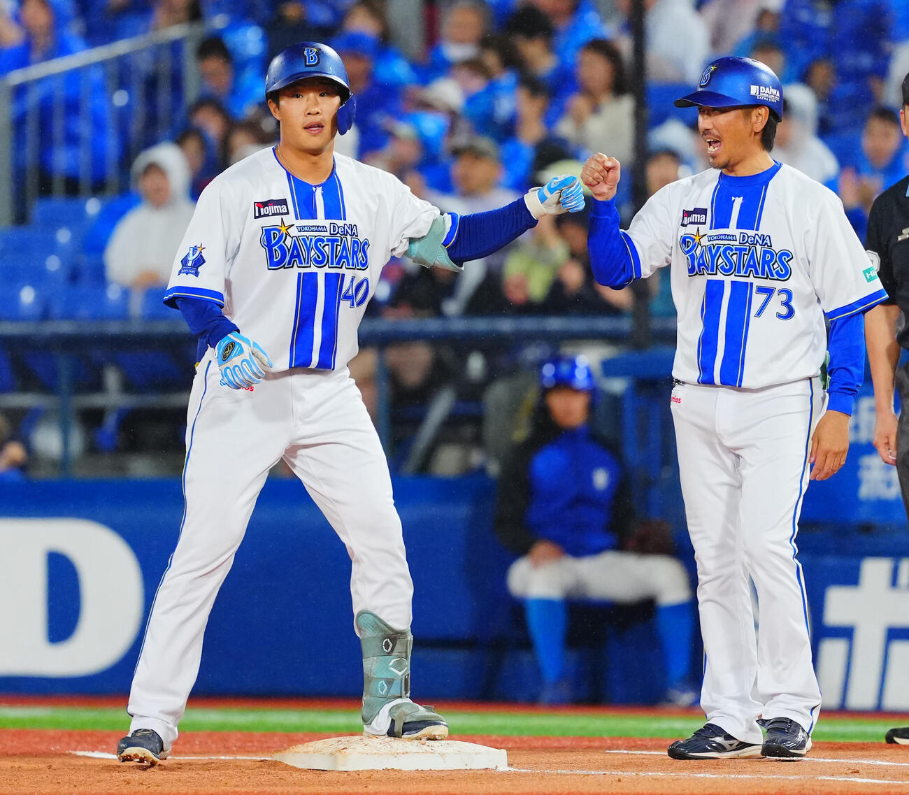 DeNA対ヤクルト　2回裏DeNA1死一塁、中前打を放ち塁上でグータッチを交わす井上朋也（左）（撮影・垰建太）
