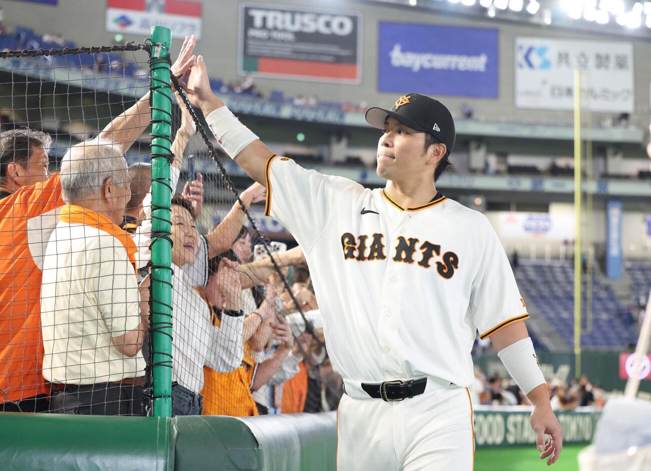 巨人対中日　試合後、ファンとハイタッチする大城卓三（撮影・黒川智章）