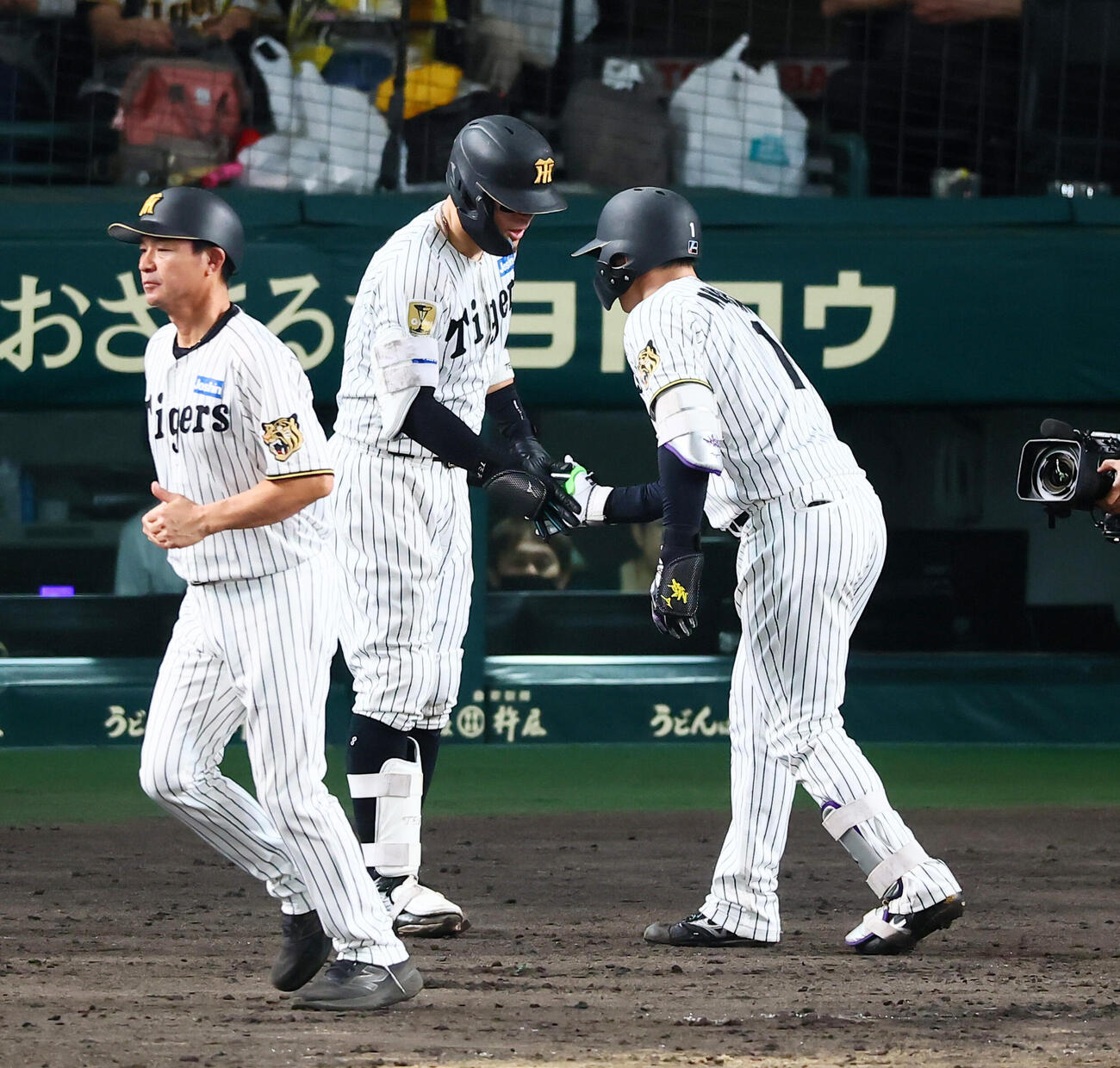 阪神対広島　9回裏阪神1死、森下翔太は中越えソロ本塁打を放ち次打者佐藤輝明（左）とタッチする（撮影・加藤哉）