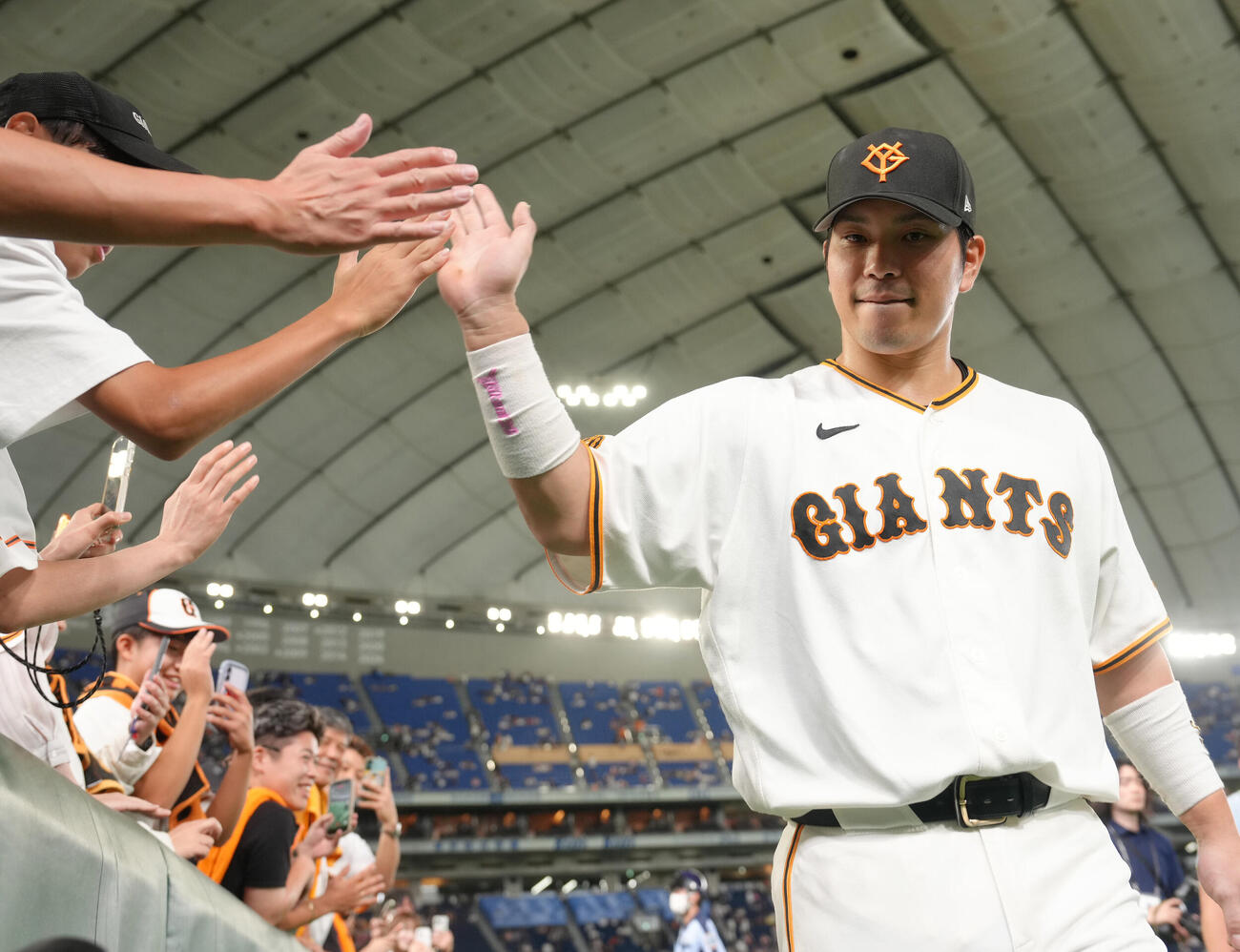 巨人対中日　試合後、ファンとタッチを交わす巨人大城卓三（撮影・足立雅史）