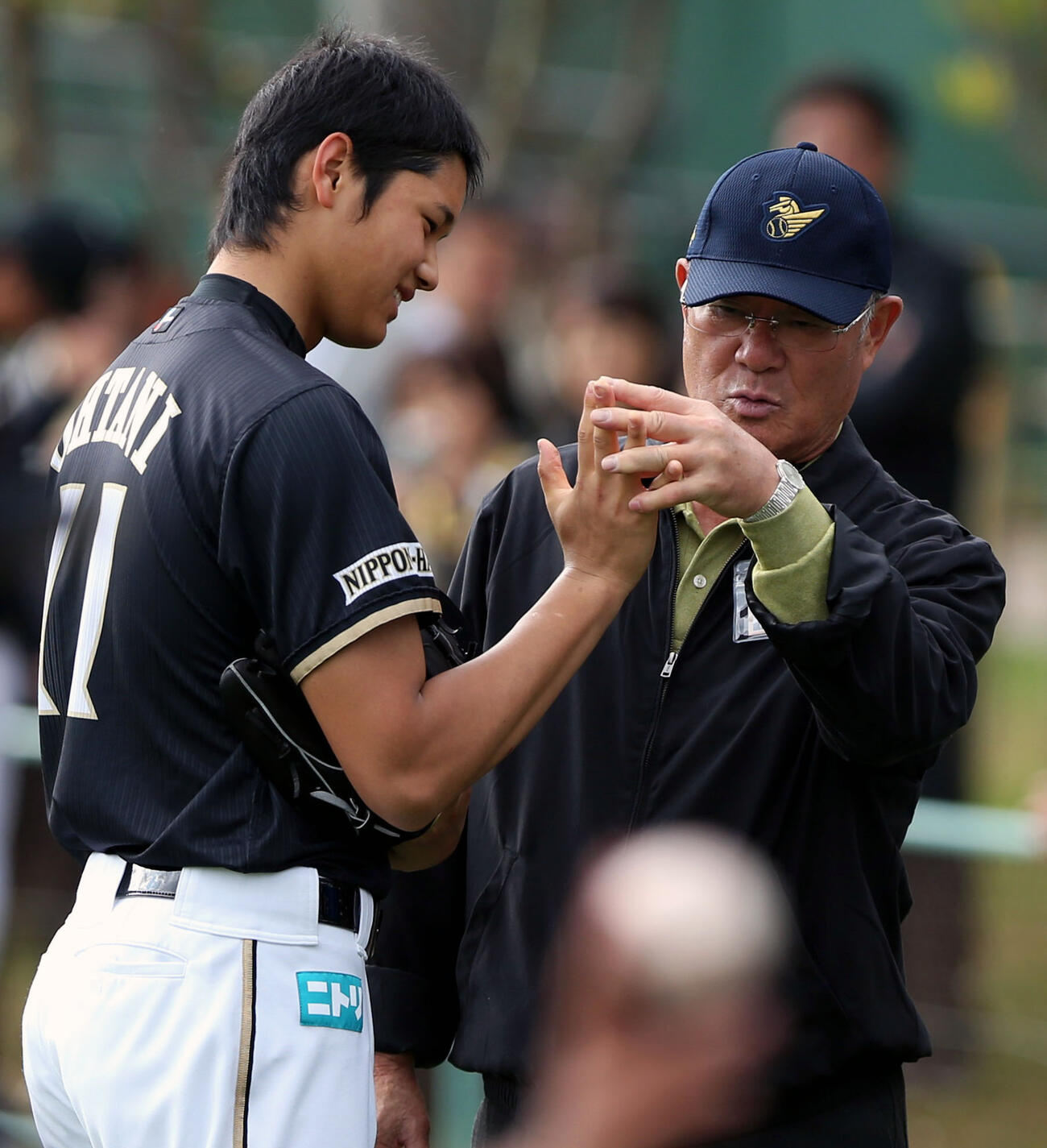 2013年2月、日本ハム沖縄・国頭2軍春季キャンプ　大谷（左）の右手を見る張本勲氏