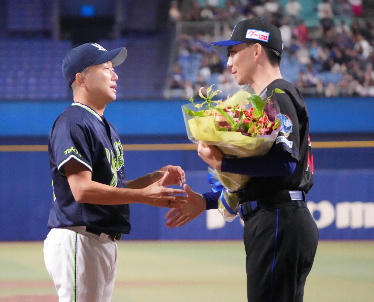 中日対ヤクルト　試合後、石川雅規（左）は中日嶋基宏ヘッドコーチから花束を受け取る（撮影・森本幸一）
