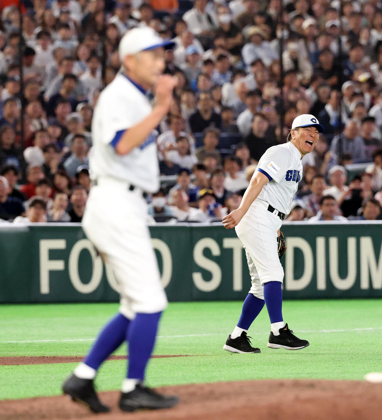 KOBE CHIBEN対高校女子選抜　7回表高校女子選抜2死、神山桃実の三塁ゴロを一塁悪送球し悔しそうな松井秀喜さん（奥）。手前はイチローさん（撮影・浅見桂子）