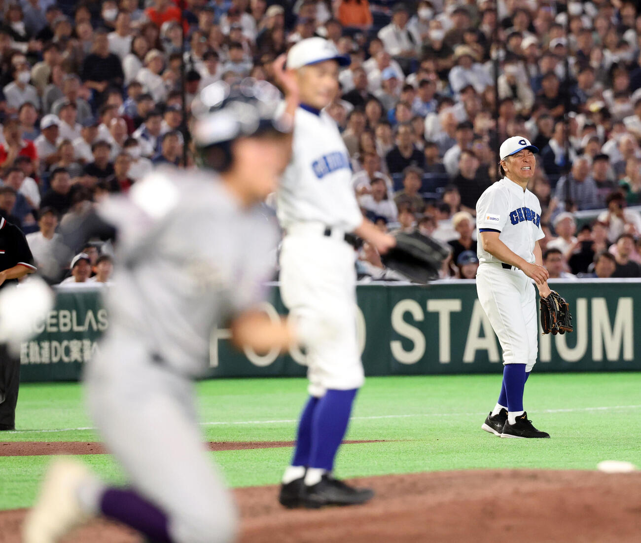 KOBE CHIBEN対高校女子選抜　7回表高校女子選抜2死、神山桃実（手前）の三塁ゴロを一塁悪送球し悔しそうな松井秀喜さん（奥）。中央はイチローさん（撮影・浅見桂子）