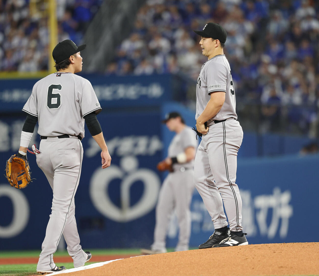 DeNA対巨人　1回裏DeNA無死一、二塁、走者を抱え小笠原慎之介（右）に声をかける坂本勇人（撮影・増田悦実）