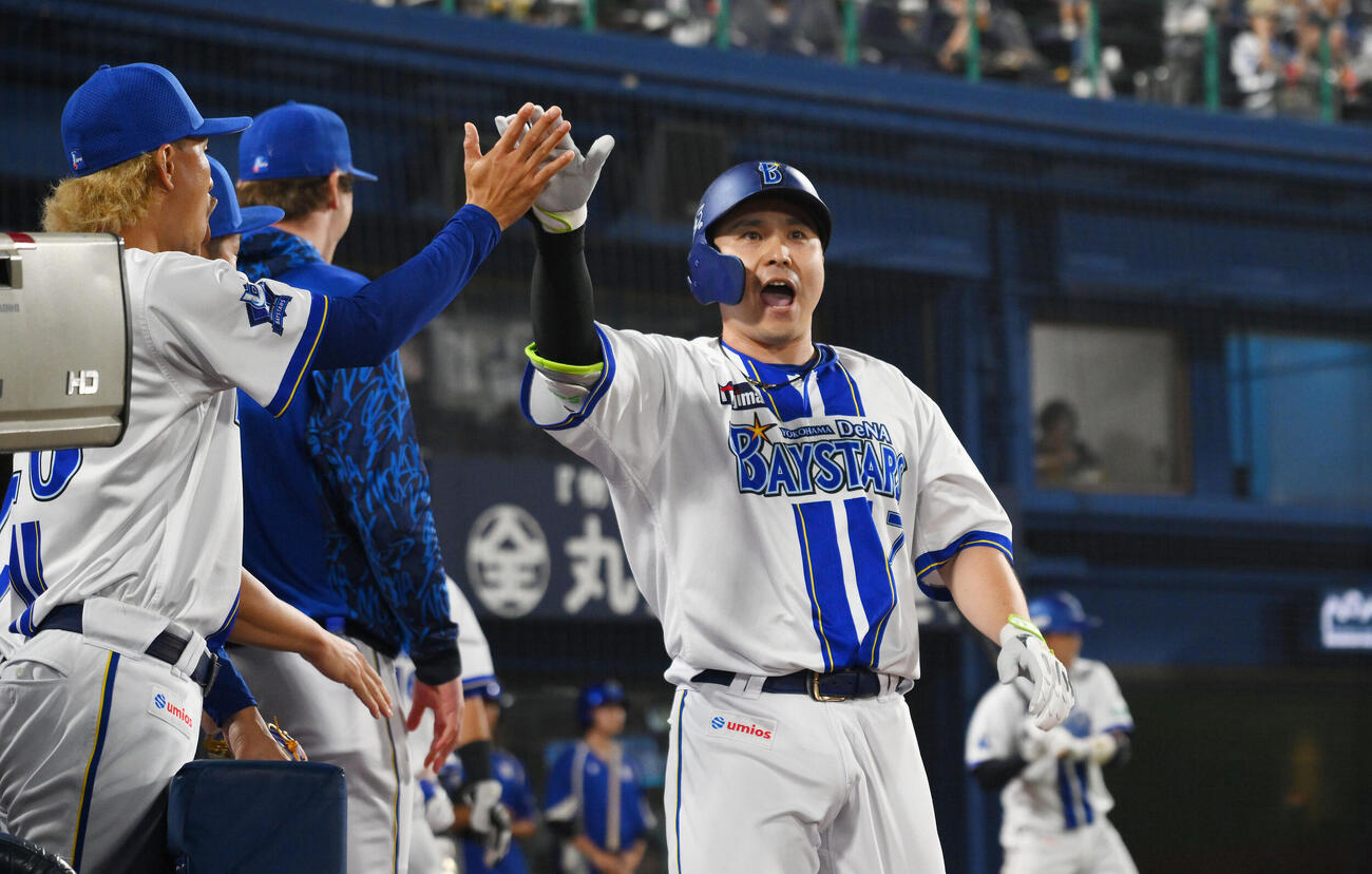 DeNA対巨人　1回裏DeNA無死満塁、先制満塁本塁打を放った佐野恵太（右）は生還しチームメートとタッチをかわす（撮影・滝沢徹郎）