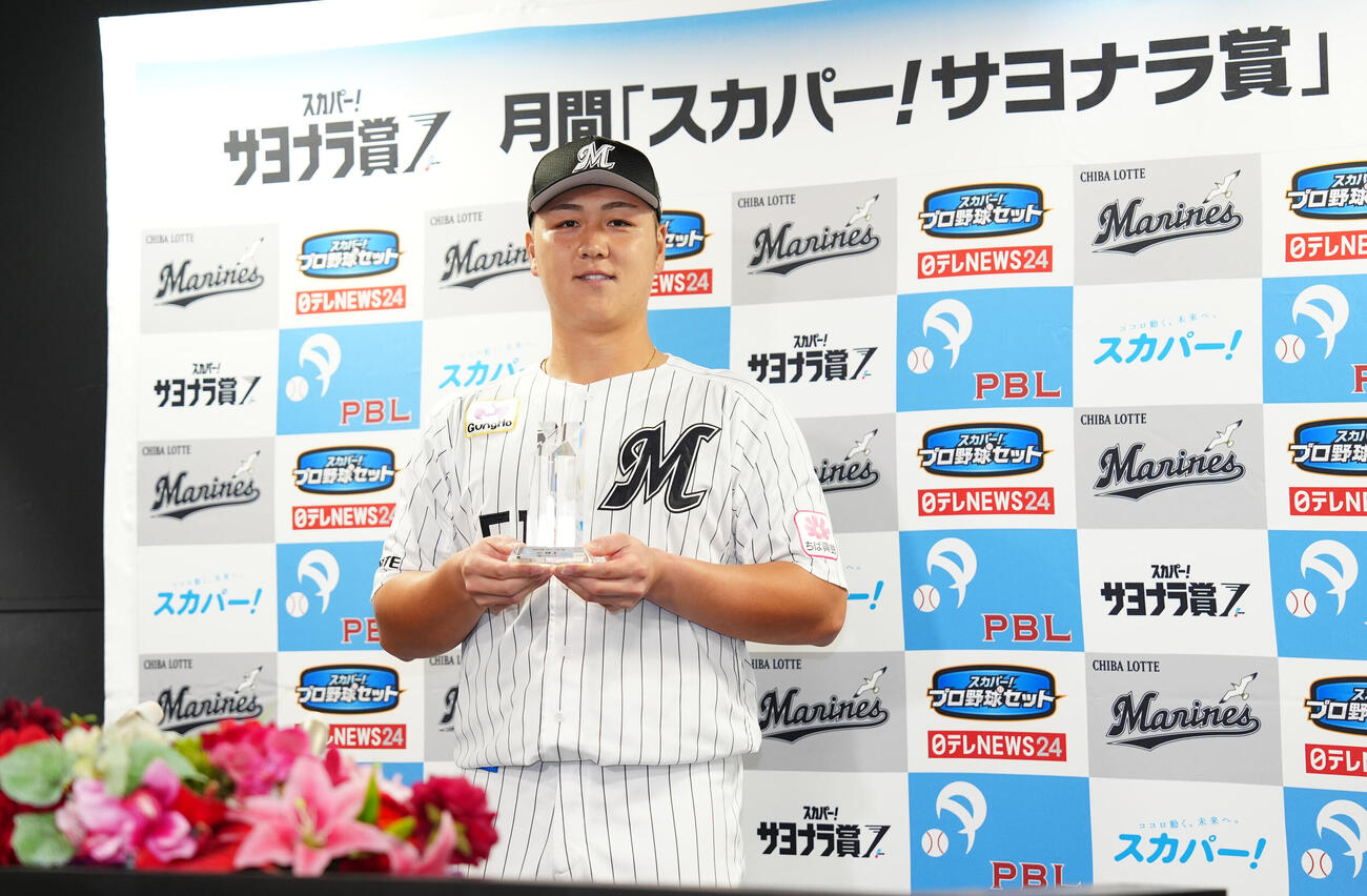 8月度スカパー！サヨナラ賞に選ばれ、トロフィーを手に写真に納まるロッテ山口航輝（撮影・鈴木みどり）