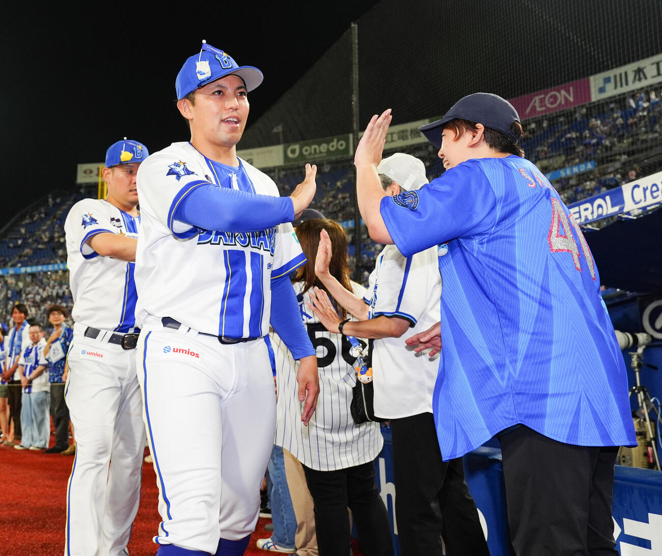 DeNA対巨人　ヒーローインタビューを終え、ファンとハイタッチするDeNA東克樹。後方は筒香嘉智（撮影・鈴木みどり）