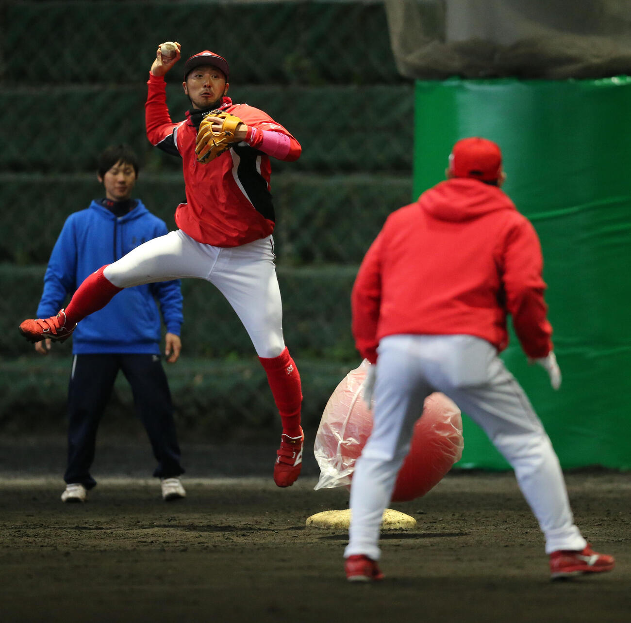 2015年広島春季キャンプ　大きなトレーニングボールを走者に見立て守備練習をする菊池。手前は石井琢朗コーチ（2015年2月4日撮影）