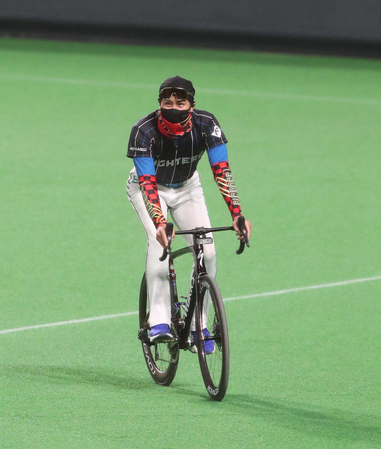 グラウンドをロードバイクで走る日本ハム新庄監督（2022年6月15日撮影）
