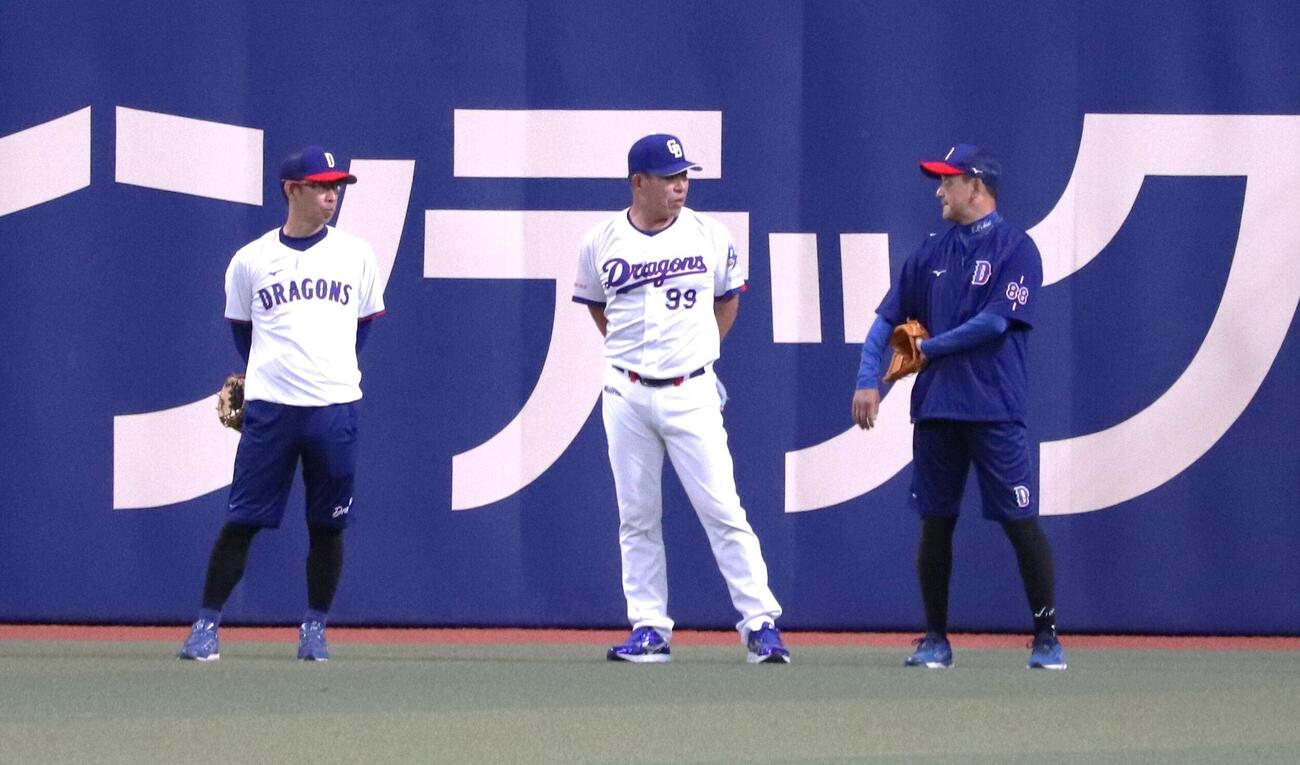 全体練習中、グラウンド後方で対話する首脳陣（左から）山井投手コーチ、井上監督、落合投手コーディネーター