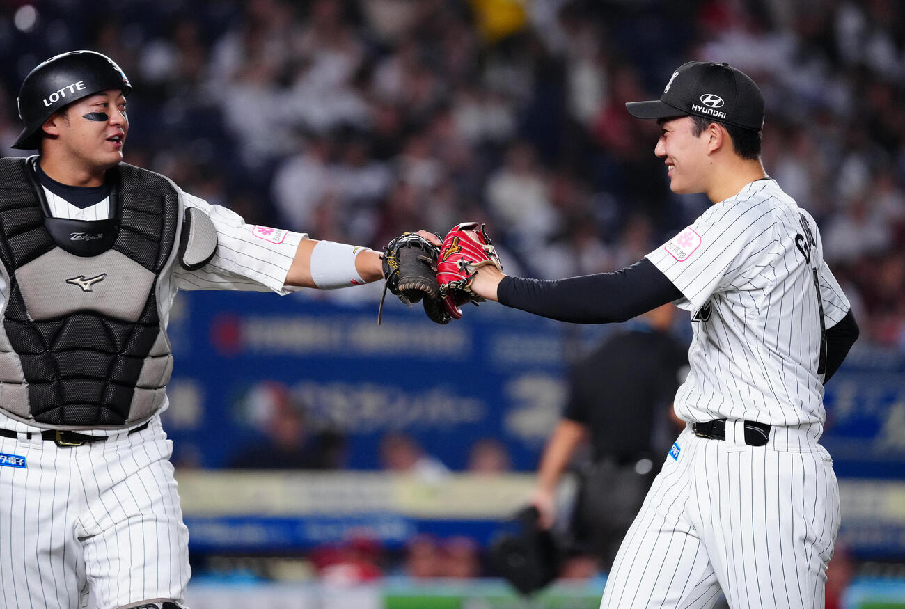 ロッテ対楽天　1回表を終え、笑顔で佐藤都志也（左）とタッチを交わすロッテ石垣元気（撮影・鈴木みどり）