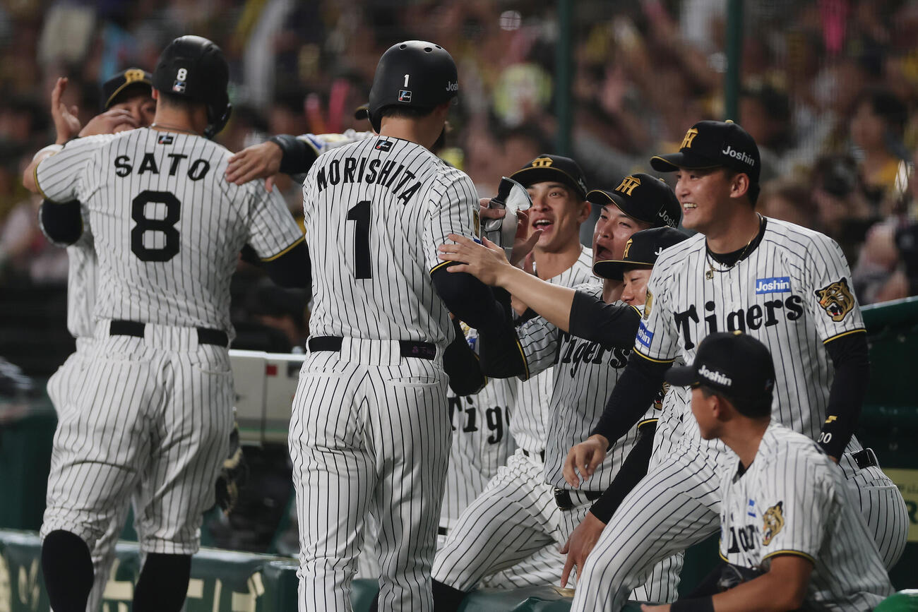 阪神対広島　1回裏阪神1死二、三塁、大山悠輔の2点適時二塁打で生還した佐藤輝明（左端）と森下翔太（同2人目）を迎える阪神の選手たち（撮影・前田充）
