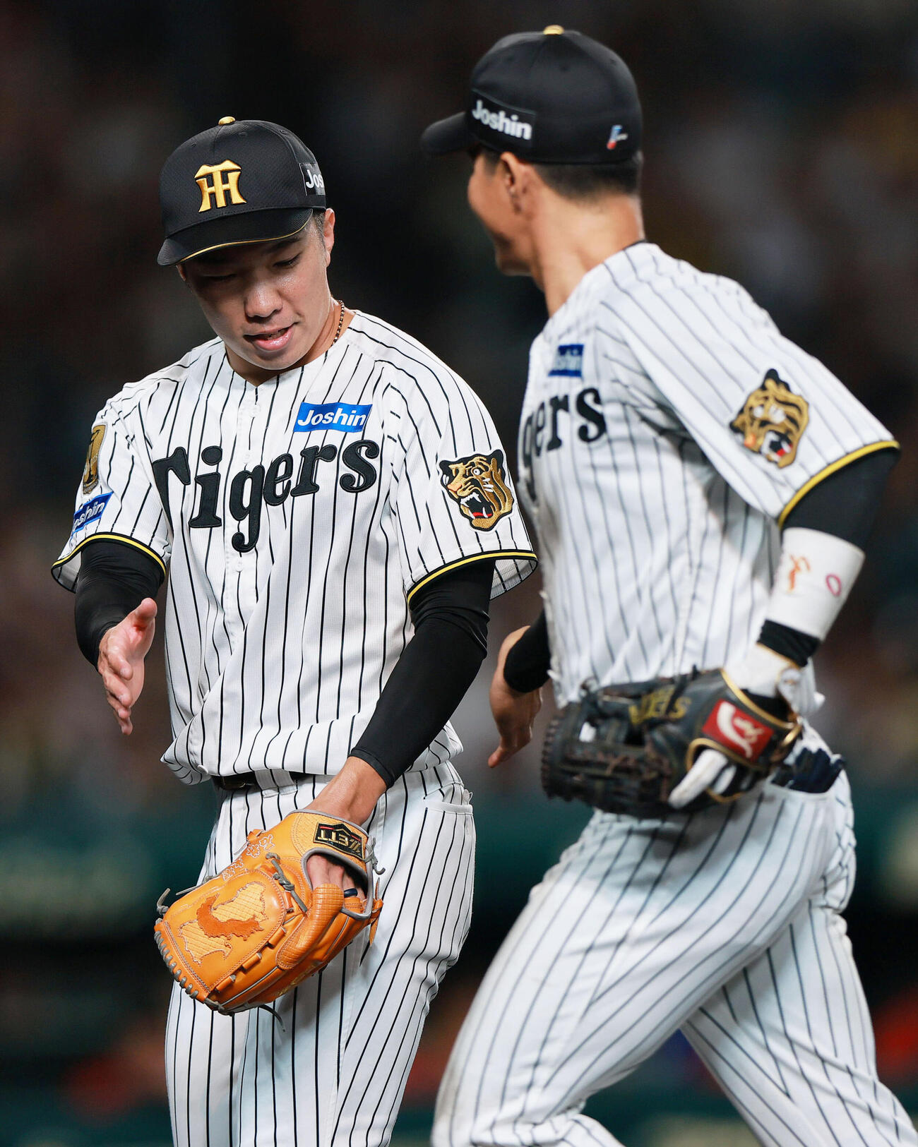 阪神対広島　8回表を無失点で投げ終えた阪神石井大智（左）は木浪聖也とタッチをかわす（撮影・上山淳一）