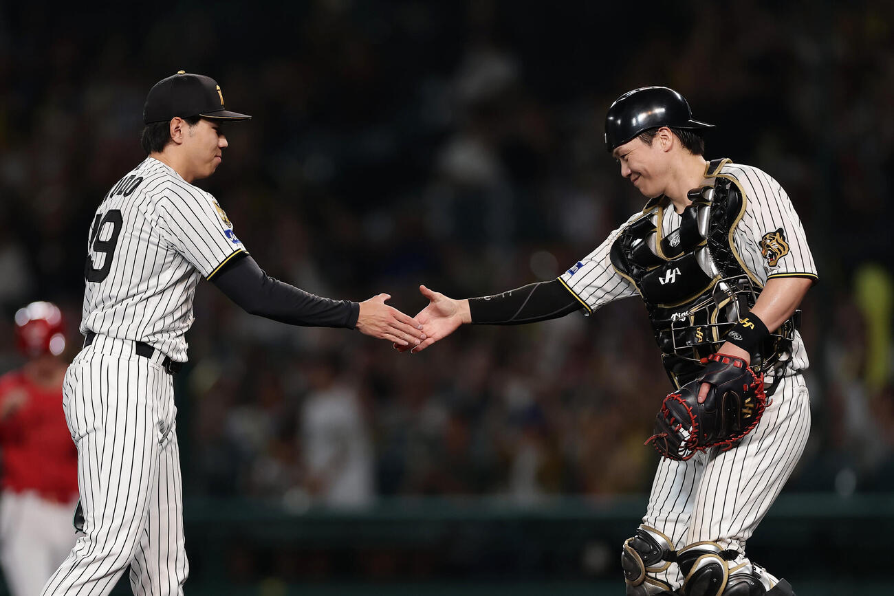 阪神対広島　広島に勝利し握手を交わす阪神工藤泰成（左）と伏見寅威（撮影・前田充）