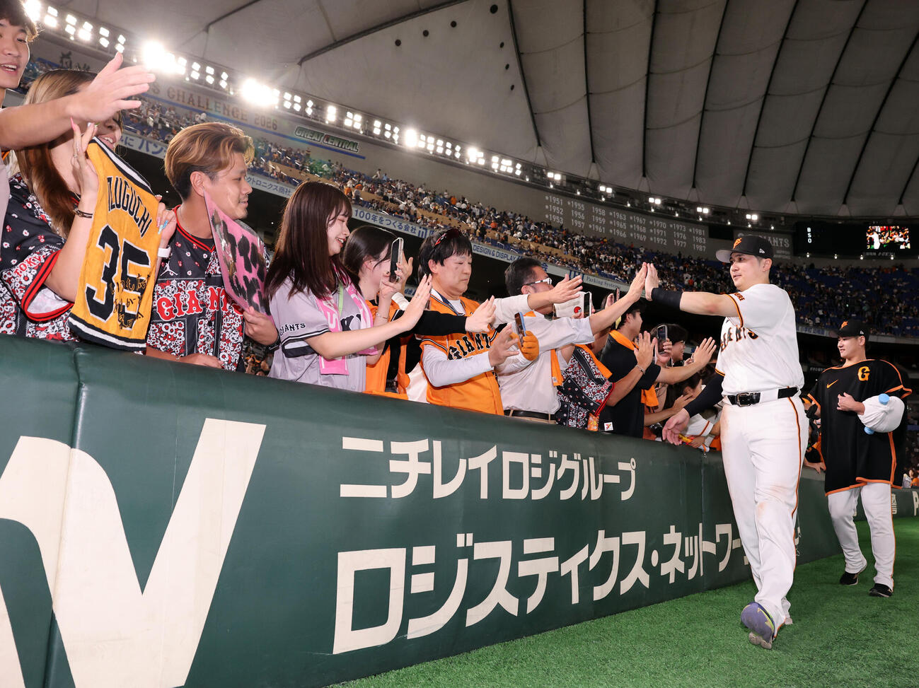 巨人対中日　サヨナラ勝利で、場内1周でファンとハイタッチする巨人泉口友汰、井上温大（撮影・浅見桂子）