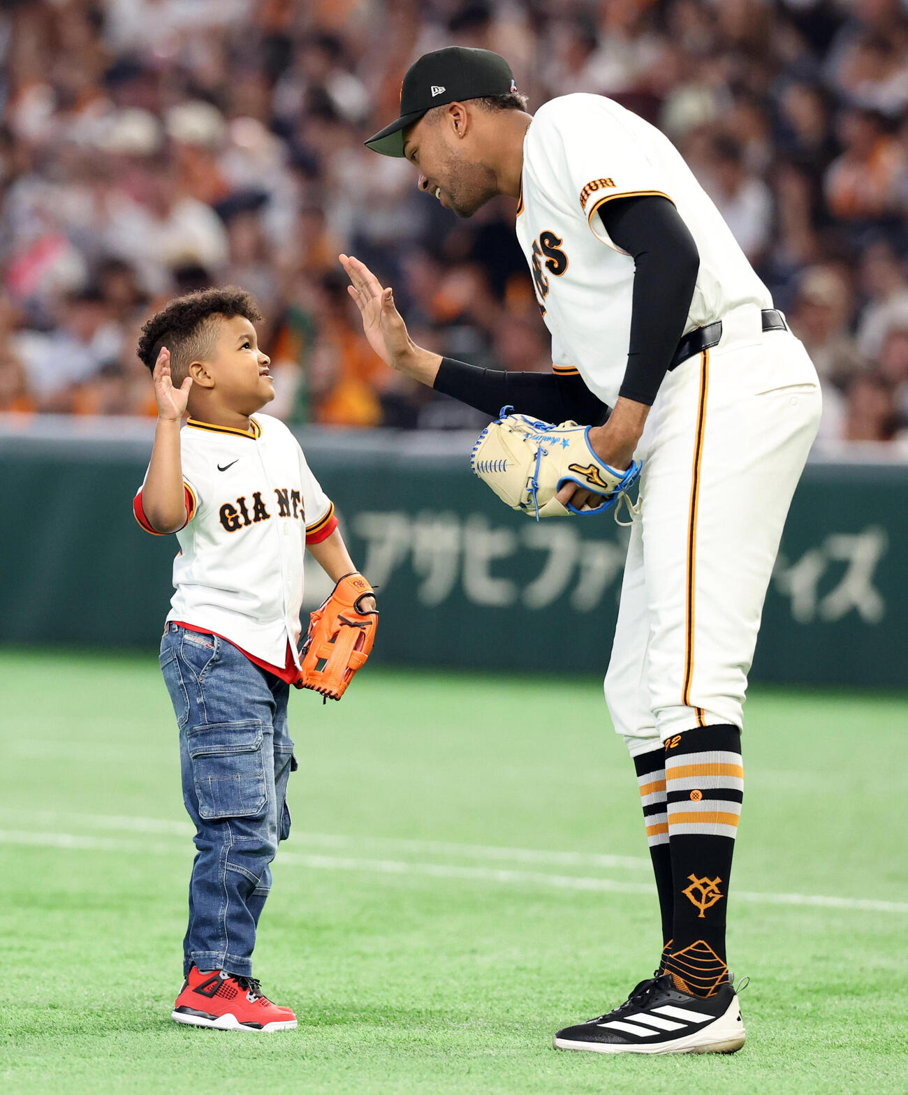 巨人対中日　セレモニアルピッチに登場した巨人ライデル・マルティネス（右）の長男ルーカス君はハイタッチ（撮影・浅見桂子）