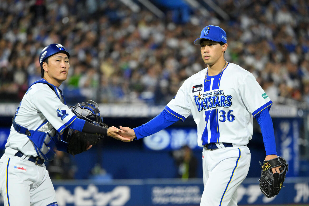 DeNA対ヤクルト　2回表を投げ終えたDeNA先発の尾形崇斗（右）は古市尊とタッチを交わす（撮影・滝沢徹郎）