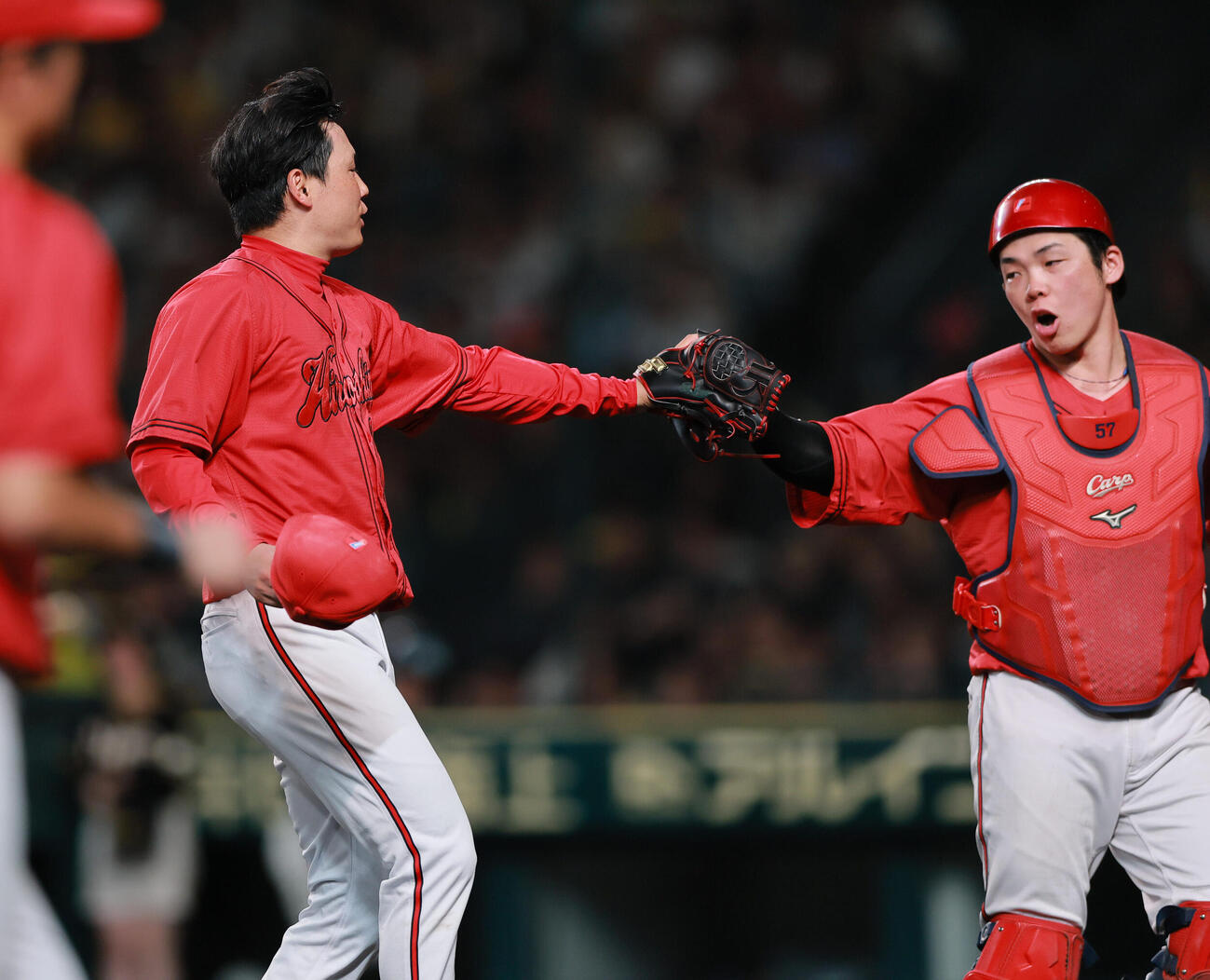 阪神対広島　7回裏阪神2死一、二塁、代打豊田寛を空振り三振に仕留め捕手持丸泰輝（右）とタッチをかわす栗林良吏（撮影・上山淳一）