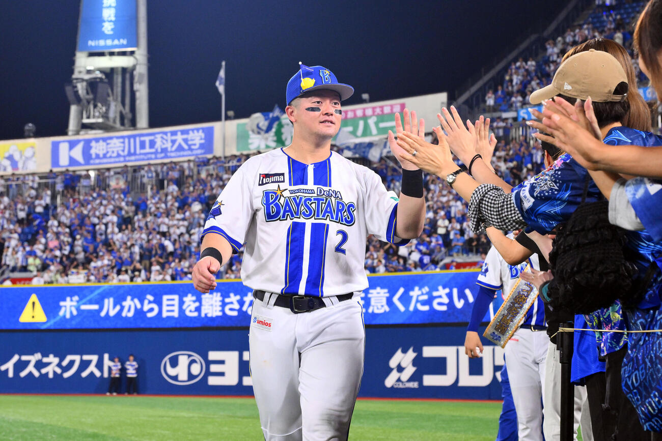 DeNA対ヤクルト　ヒーローインタビューを終えたDeNA牧秀悟はファンとタッチを交わす（撮影・滝沢徹郎）