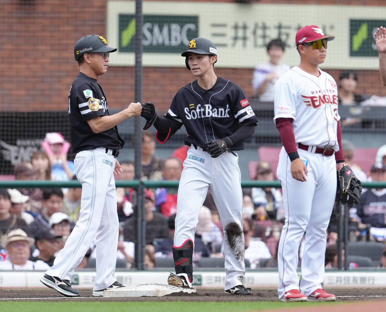 楽天対ソフトバンク　2回表ソフトバンク2死一、二塁、庄子雄大（中央）は先制2点適時三塁打を放ちタッチを交わす（撮影・足立雅史）