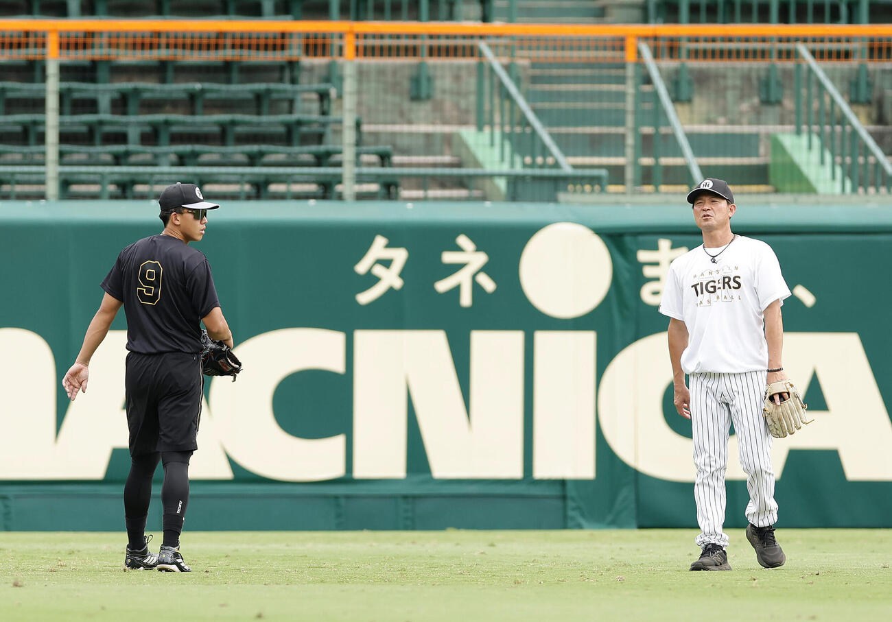 阪神対DeNA　筒井壮コーチ（右）の指導を受けながら外野での守備練習に励む阪神立石正広（撮影・前田充）