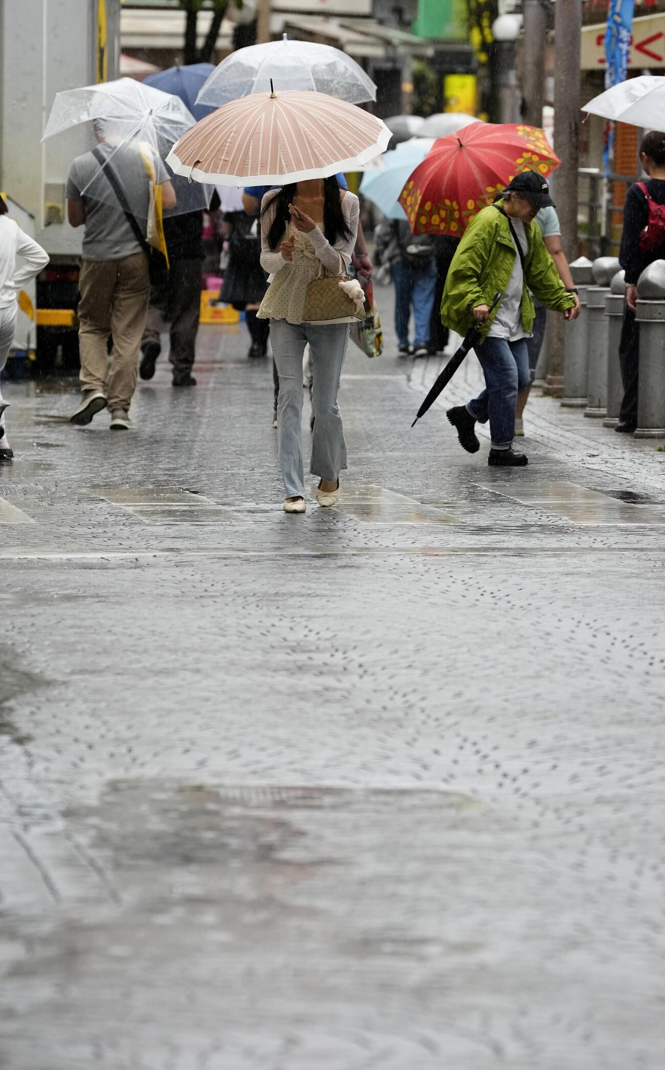 雨の中を歩く人たち（共同＝20日午後、千葉市）